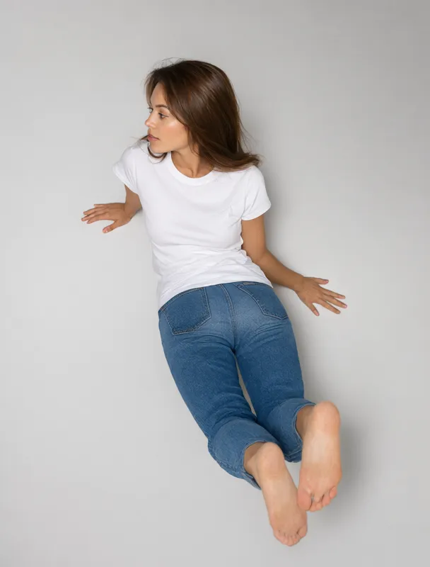 lying on her stomach propped on her elbows with her feet kicked up by qwen image 2.1